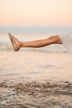 A Woman in the Beach Wearing Wet Sandals