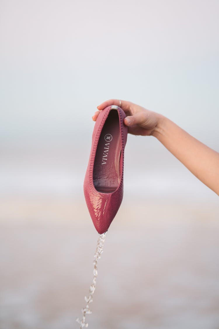 A Person Holding A Pink Shoe