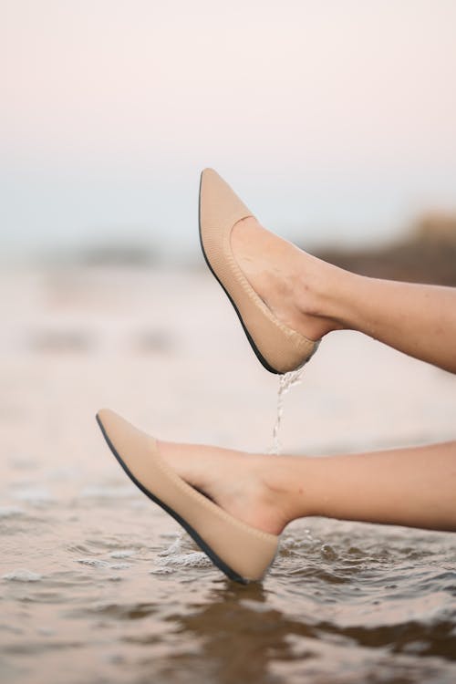 A Woman Wearing Wet Brown Slip on Sandals