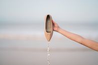 Person Holding Brown Shoe With Water