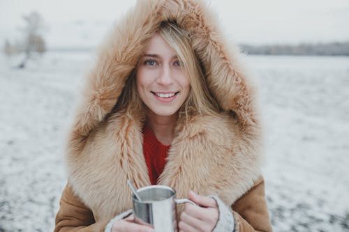 Woman in a Fur Coat Holding a Coffee Thermos 