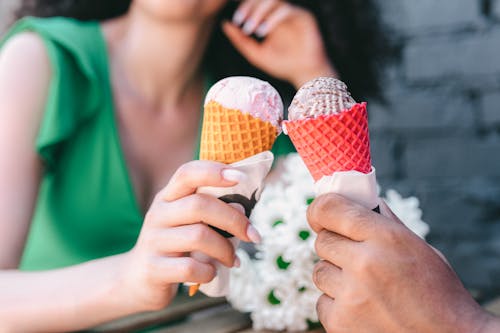 Close-Up Photograph of Hands Holding Cones with Ice Cream