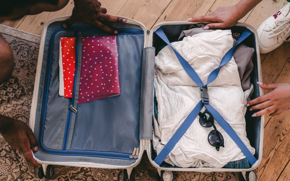 A neatly packed open suitcase with clothing and travel essentials, ready for a trip.