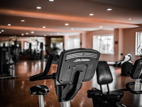 A modern gym interior featuring stationary exercise bikes and equipment for fitness enthusiasts.