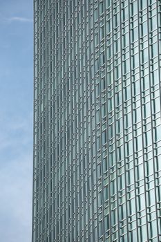 A vertical shot of a modern glass skyscraper in Central Jakarta, Indonesia.