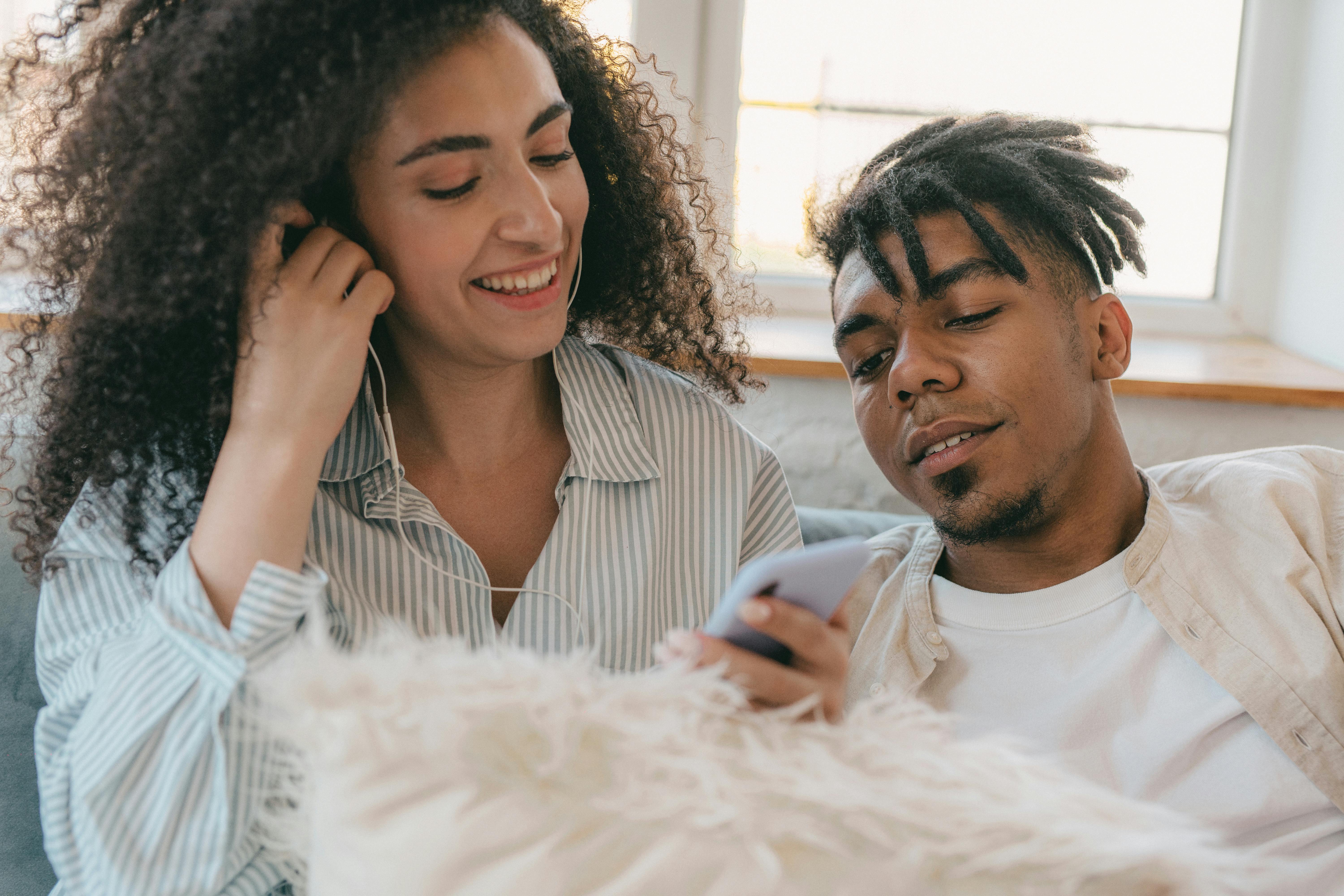 man with dreadlocks sitting beside the woman