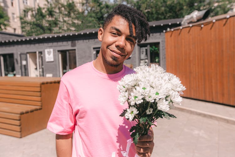 A Man In Pink Crew Neck T-shirt Holding Bouquet Of Flowers