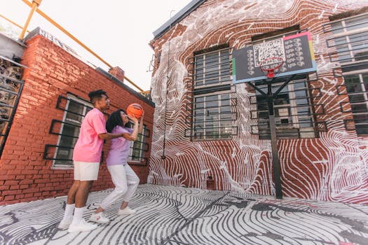 Interracial couple enjoying a friendly basketball game by a vibrant mural.