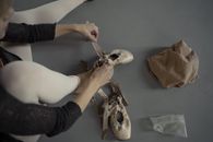 Person in Black Long Sleeves Wearing Ballet Shoes