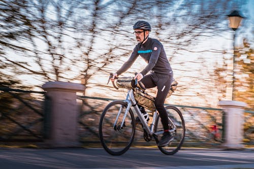 Man in Black Long Sleeve Shirt Riding Black and Silver Bicycle