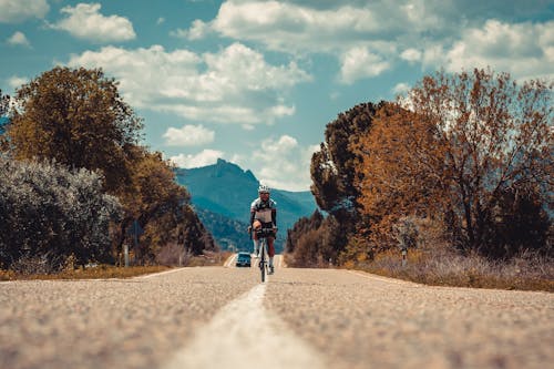 Free Low-Angle Shot of a Person Riding a Bicycle on the Road Stock Photo