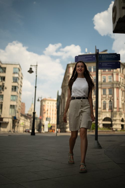 Woman in White Sleeveless Shirt Standing on Sidewalk