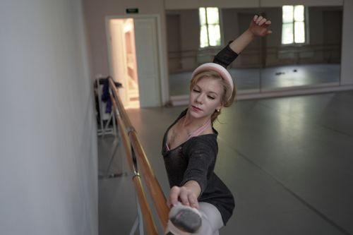 Free Graceful ballerina practicing at barre in a serene dance studio. Stock Photo