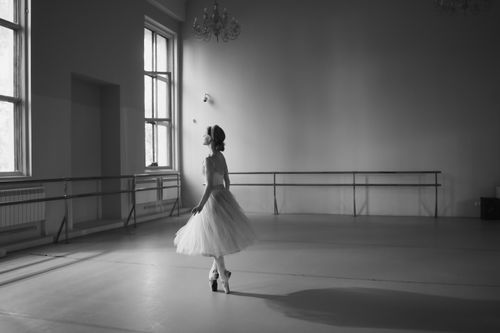 Free Graceful ballerina captured in a monochrome ballet studio setting, exuding elegance and discipline. Stock Photo