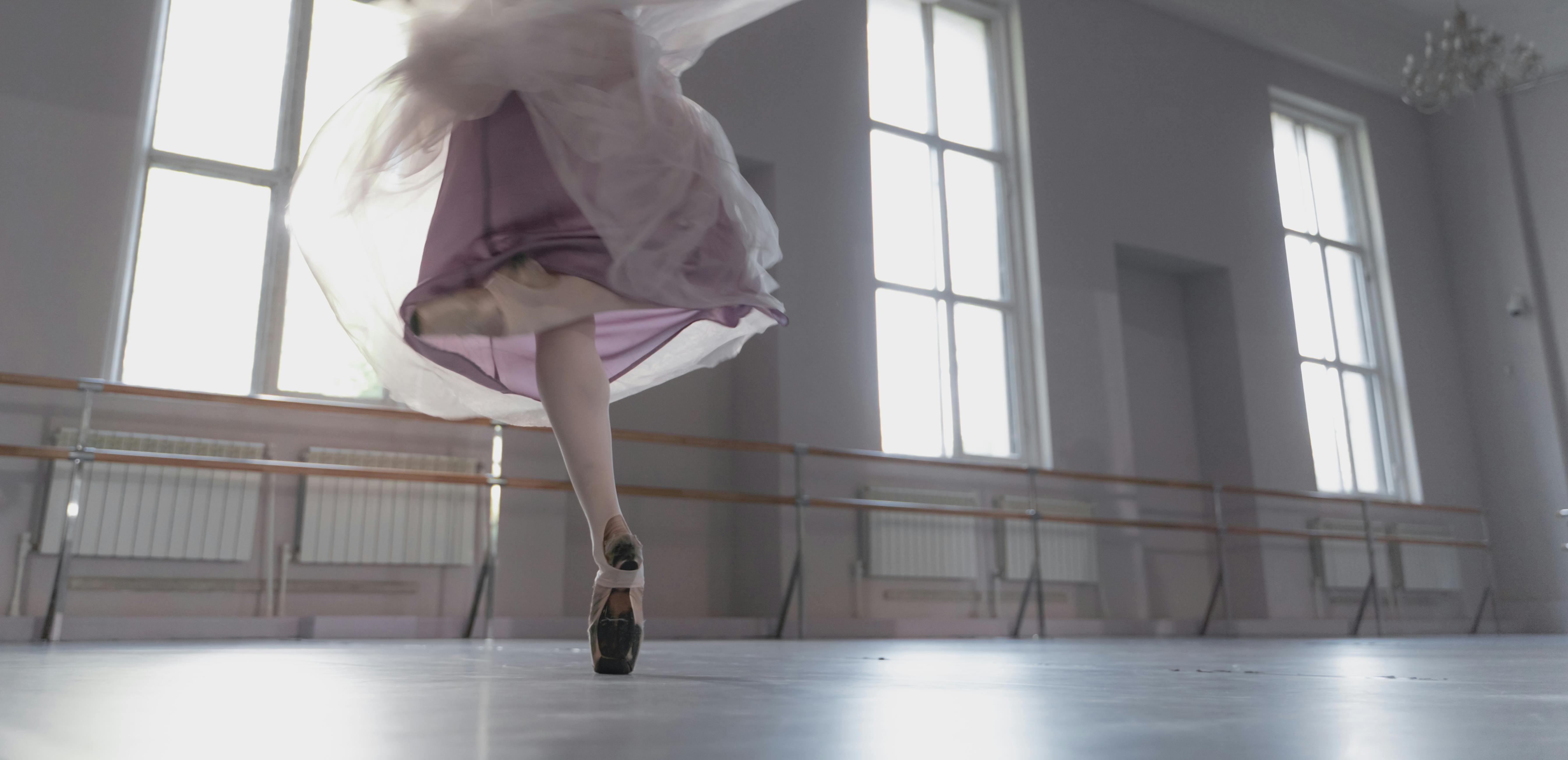 woman in pink dress wearing white ballet shoes