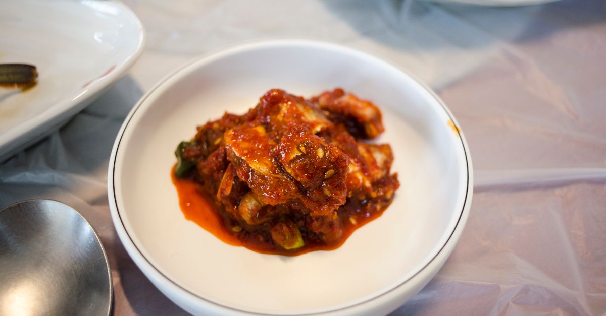 a close-up of a spoonful of kimchi with visible chili flakes and garlic pieces