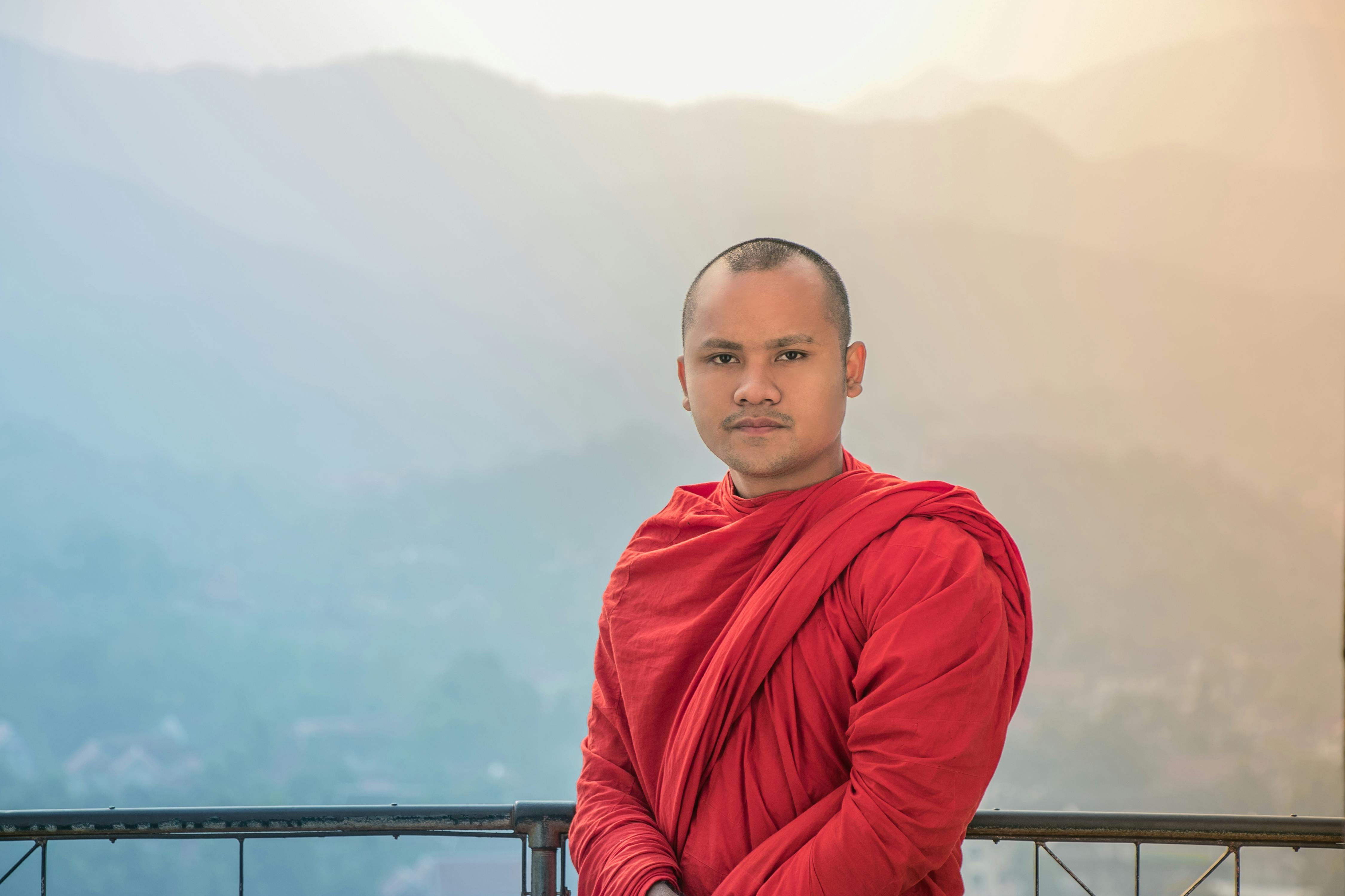 一位僧人穿着红衣，背景是雾蒙蒙的群山