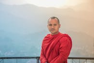 一位僧人穿着红衣，背景是雾蒙蒙的群山