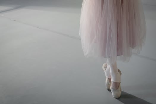 Close-up of a ballerina on pointe highlighting grace and elegance in a dance studio.
