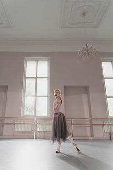 A ballerina gracefully poses in a sunlit dance studio, showcasing elegance and poise.