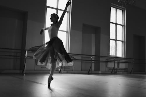 A Grayscale of a Woman Practicing Ballet