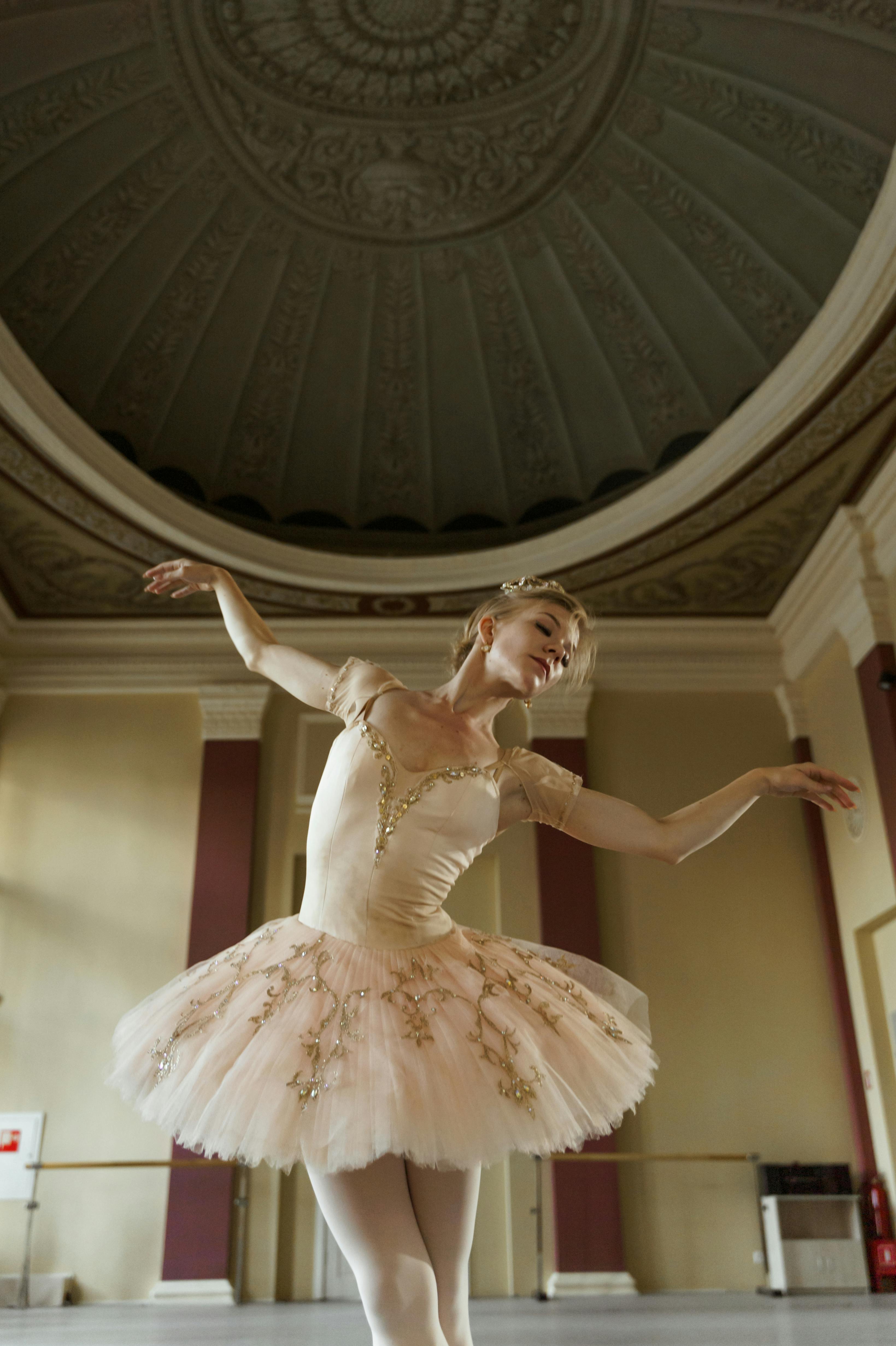 Free A graceful ballerina dances elegantly in a classical indoor setting. Stock Photo