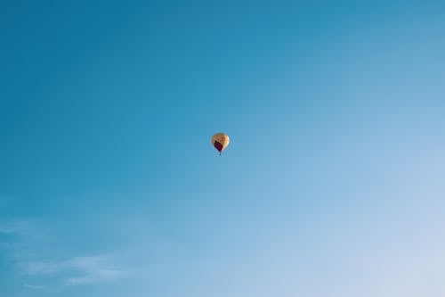 Yellow Red Hot Air Balloon in Mid Air Under Blue Sky