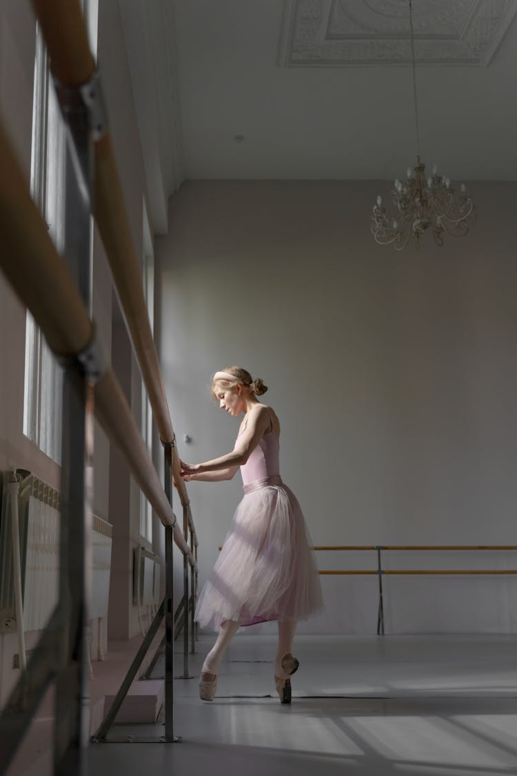 Woman In Pink Dress Holding On Barre