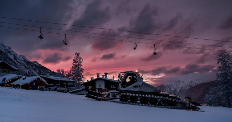 Chair Lift Above Snowy Hill At Sunset