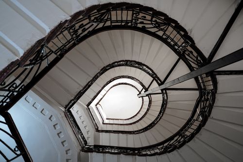Free Artistic view of an elegant spiral staircase with intricate railing design. Stock Photo
