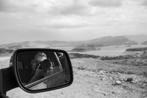 Free A Reflection of a Man Using a Camera Stock Photo