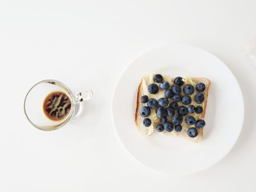 Free A delicious blueberry toast paired with a clear cup of coffee on a white background. Stock Photo