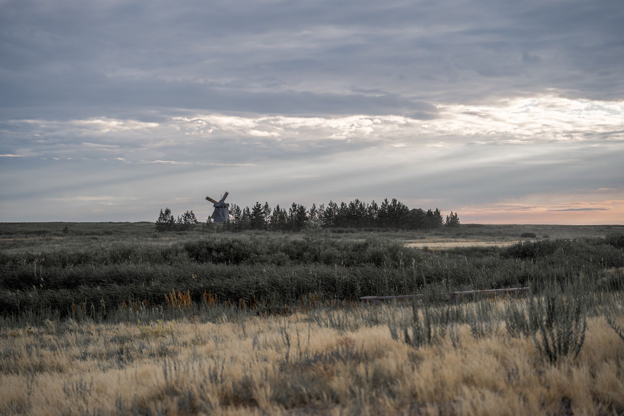 Captivating landscape of Arkaim in Russia featuring a lone windmill under a dramatic gray sky.