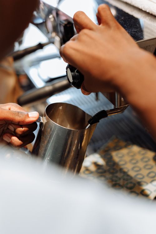Free Close-up of a barista using a frothing jug for espresso preparation. Stock Photo