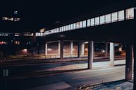 An Enclosed Footbridge Over a Road at Night