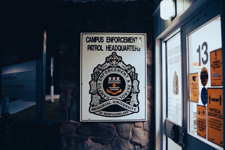 Sign Of Campus Police On Wall By Entrance