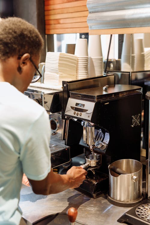 Man in White T-shirt Standing in Front of Espresso Machine