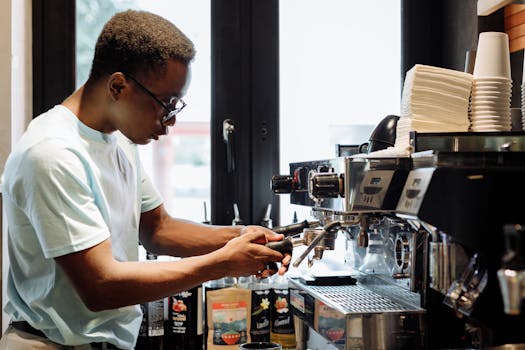 A barista prepares coffee with an espresso machine in a cozy cafe setting.