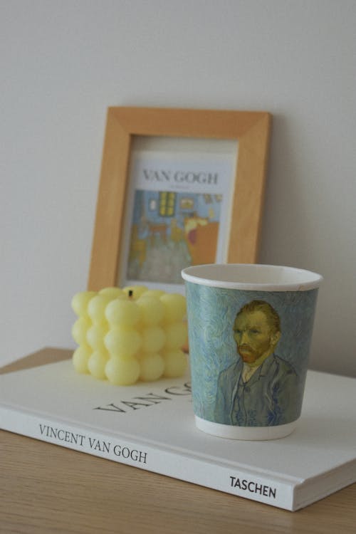 Free Vincent Van Gogh Book Beside A Painting On Frame and Paper Cup Stock Photo