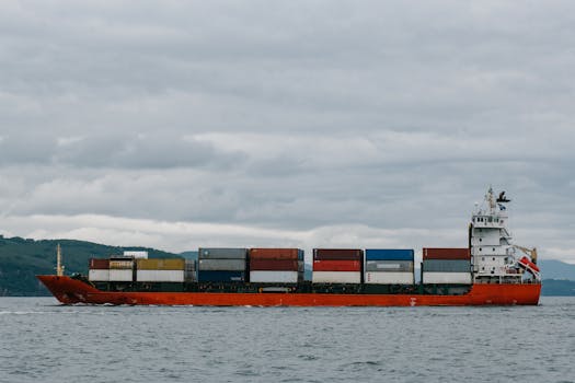 Container ship navigating the waters of Kamchatka, Russia, against a cloudy sky.