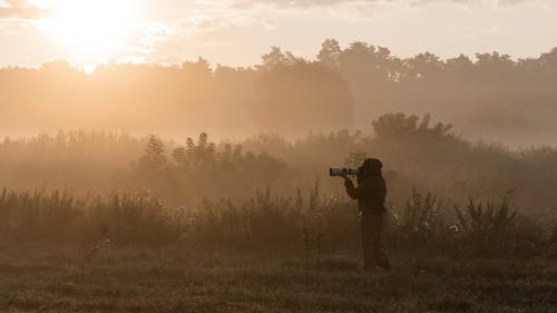 Free A Person Taking Pictures during Sunrise Stock Photo