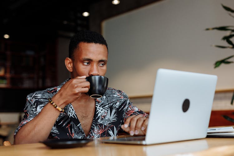 A Man Drinking Coffee While Working 