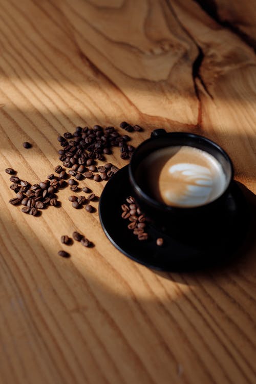 Coffee Beans and a Cup of Coffee on a Wooden Table