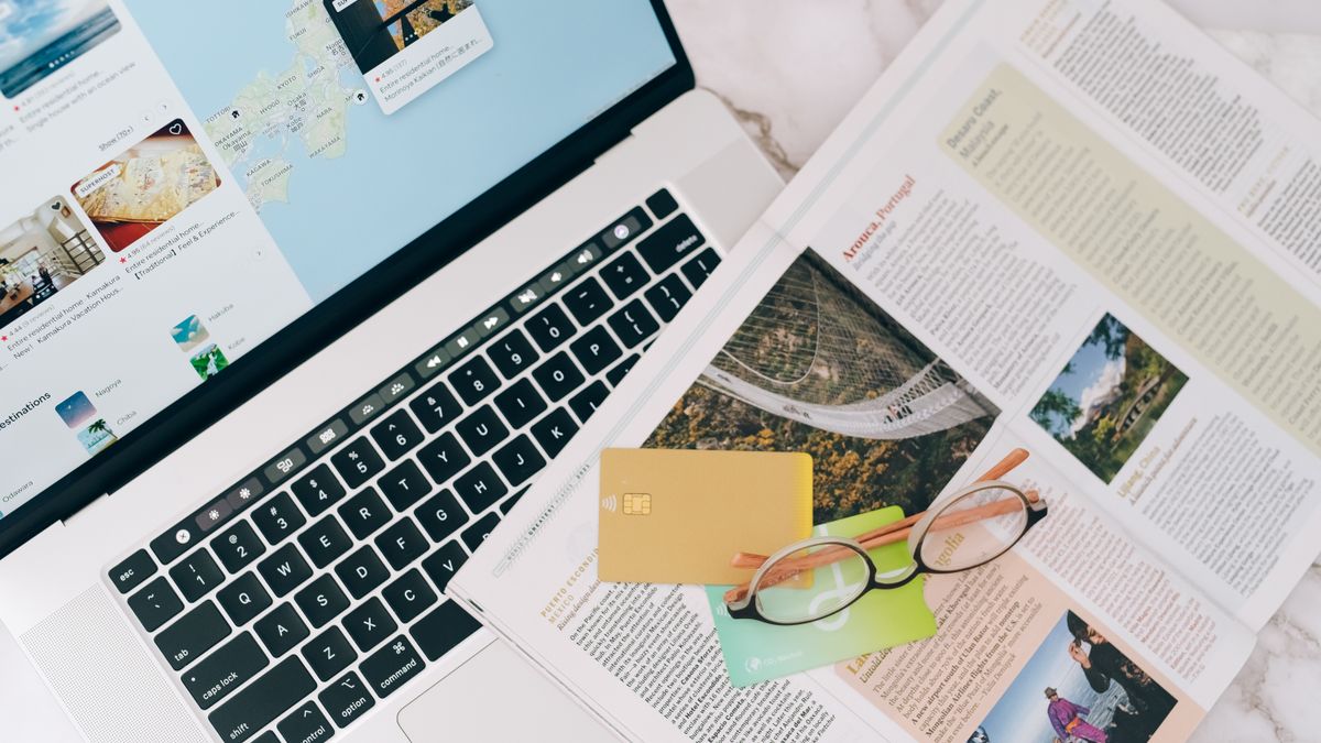 Laptop, map, and credit card laid out for travel planning, illustrating how hotel prices now vary between booking platforms