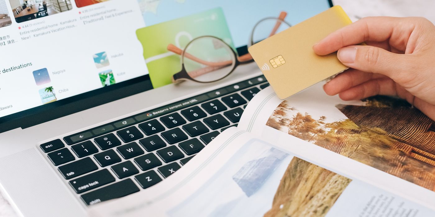 Booking a hotel online with a laptop and credit card, comparing cashback and travel portal options