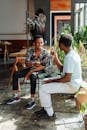 Man in White Crew Neck T-shirt Sitting on Brown Wooden Chair