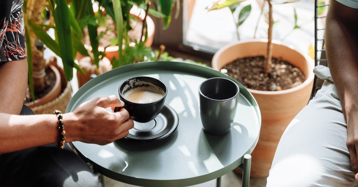 close up of a coffee cup on a table with people in background