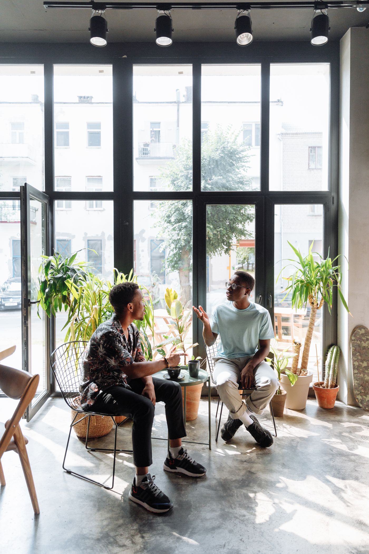 Two people talking in a bright urban cafe