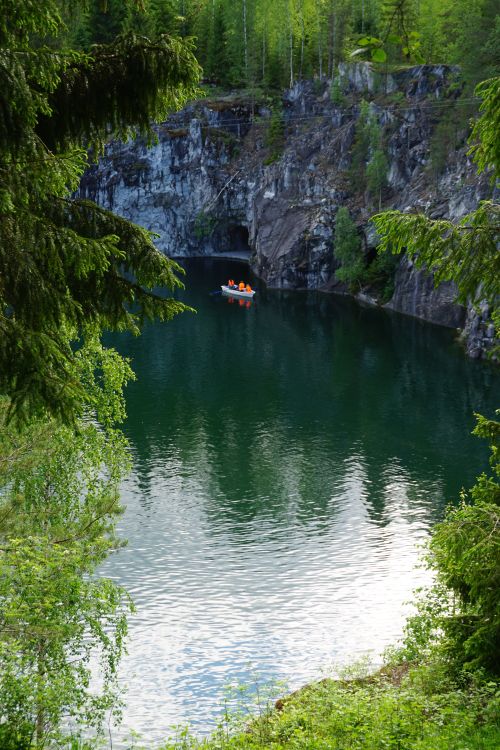 Free Peaceful canoeing scene amid lush greenery and cliffs at Ruskeala, Karelia. Stock Photo