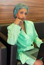 Woman in Teal Blazer Sitting on Chair